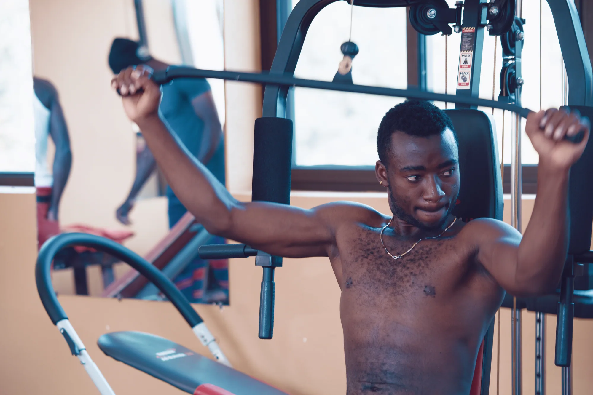 A guest working out on the lat pulldown machine in the gym