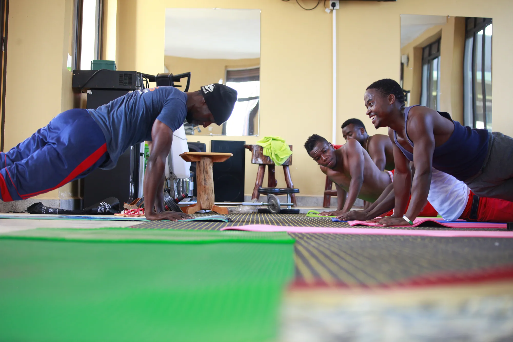A group holding plank positions on mats during a training session in the gym
