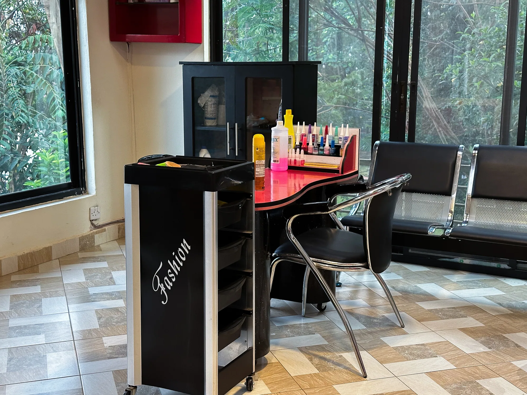 A styling station with a product cabinet beside the salon's window wall