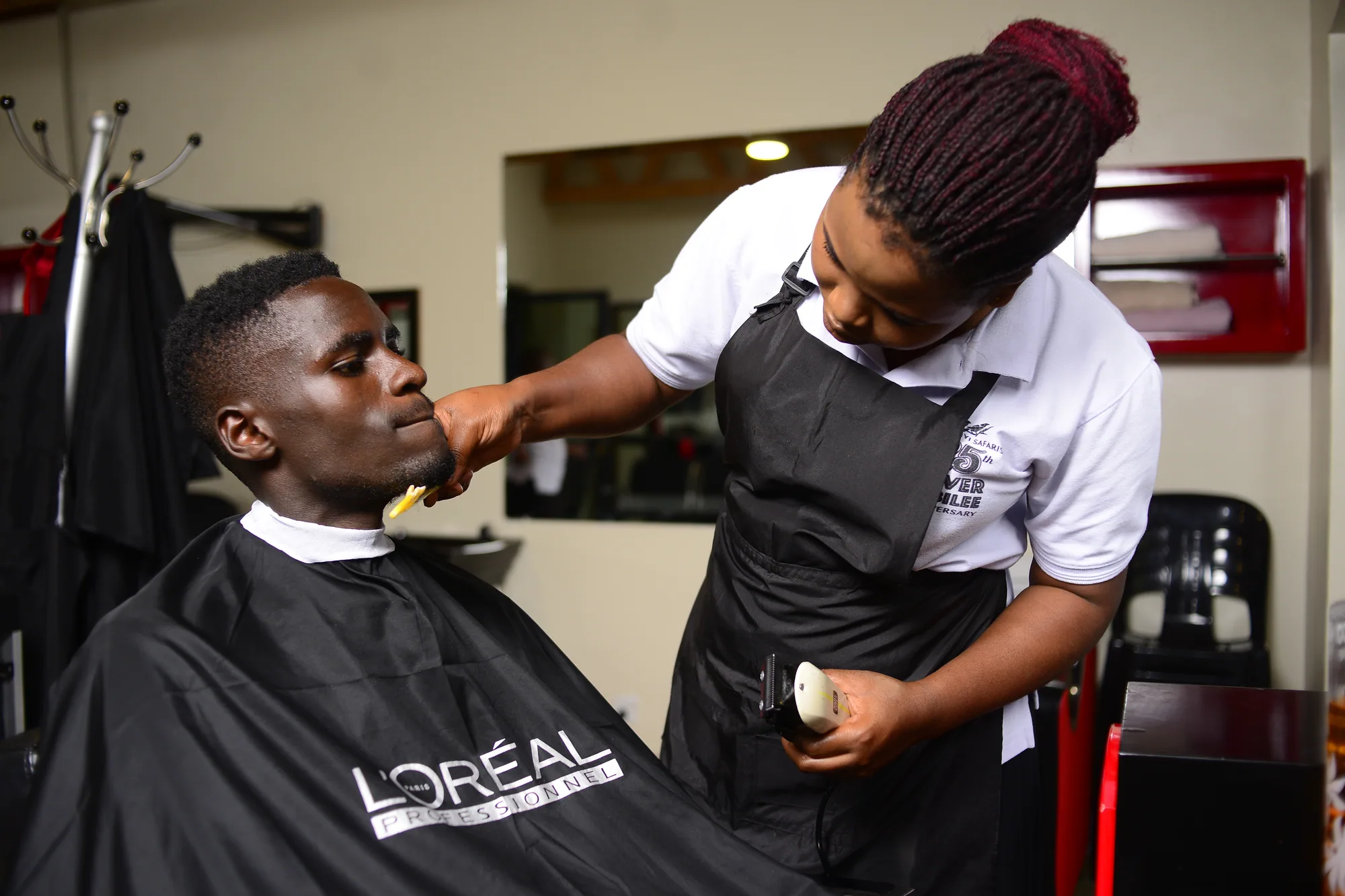 A stylist trimming a client's beard in the salon