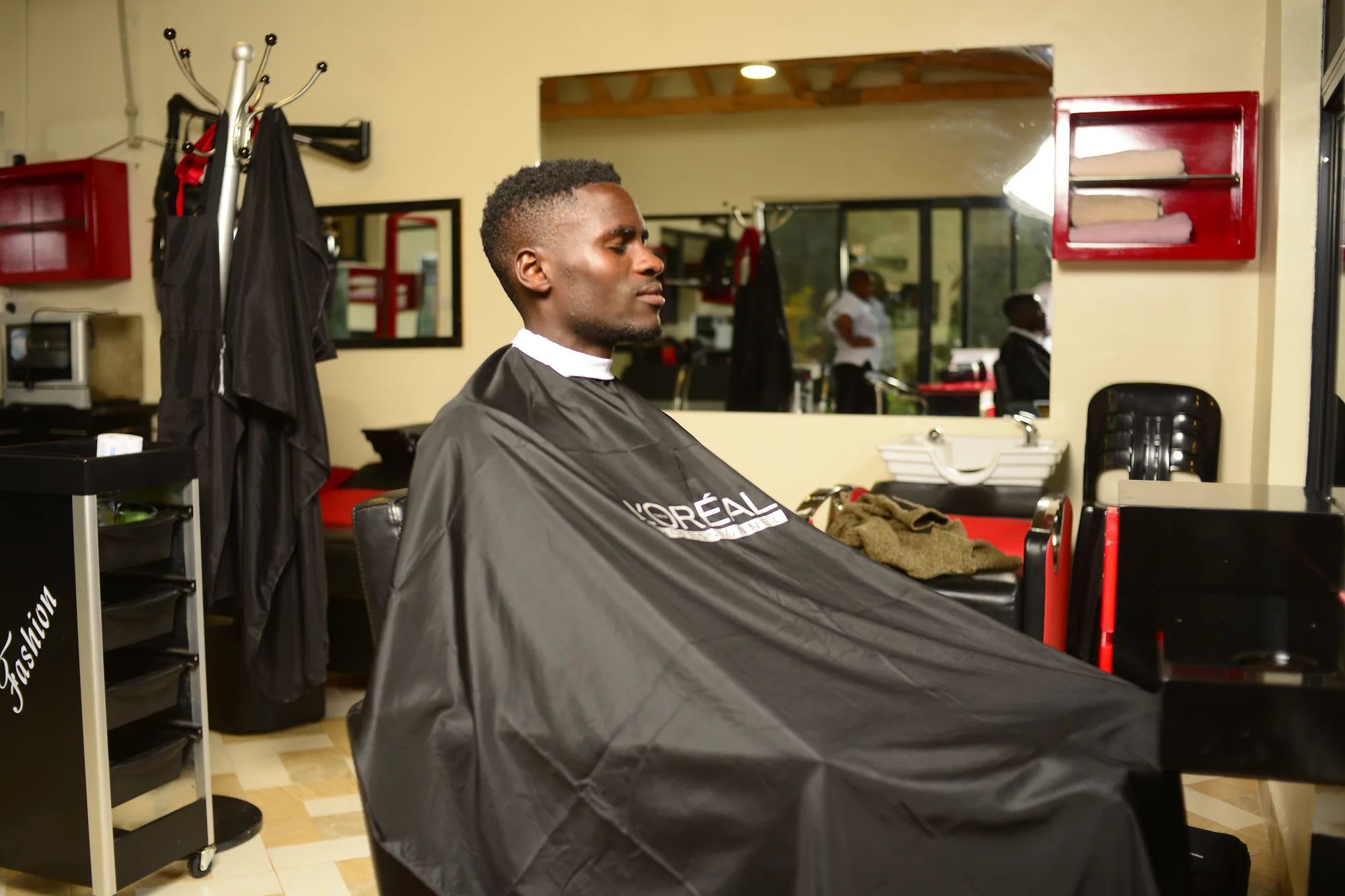 A client in a salon gown seated in front of the mirror