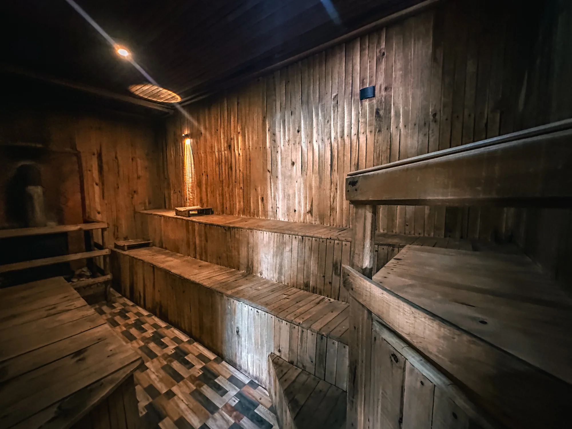 The timber-lined sauna with its tiered benches and low lighting