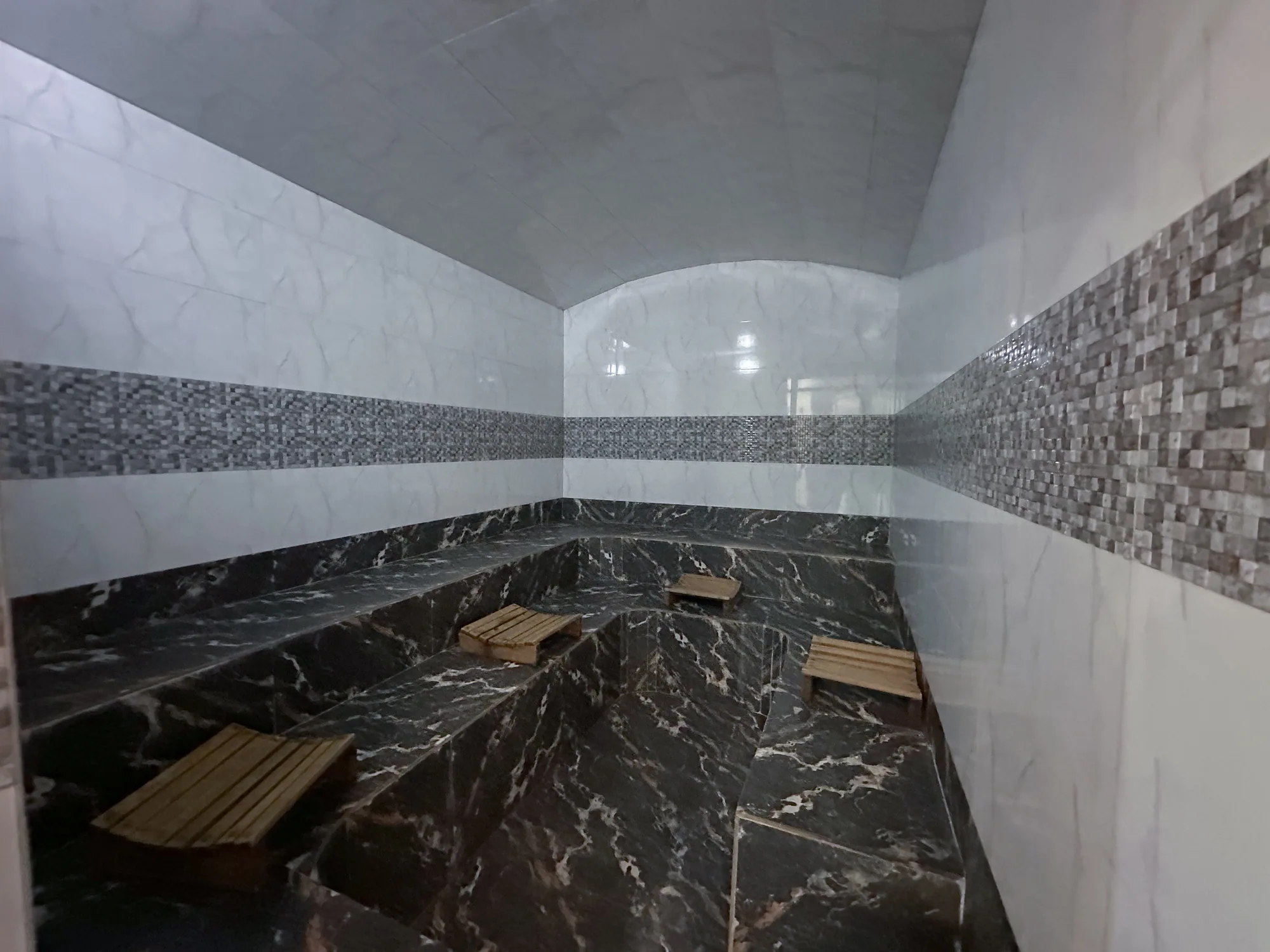The marble-lined steam room with its slatted seating
